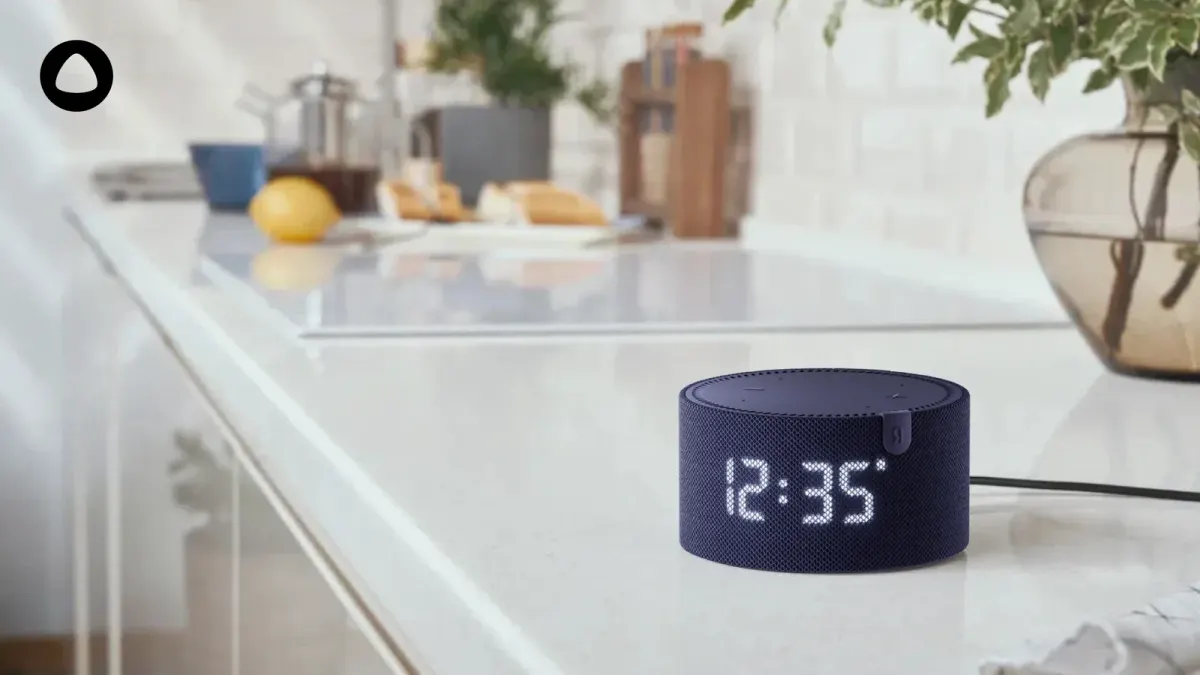 Echo Dot-style smart speaker with clock display on a kitchen counter in a UAE home setting Echo Dot-style smart speaker with clock display on a kitchen counter in a UAE home setting