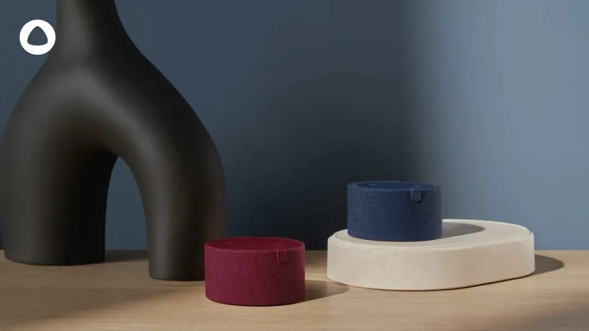 Two fabric smart speakers beside a decorative sculpture, relevant to comparing voice assistant options for a UAE home Two fabric smart speakers beside a decorative sculpture, relevant to comparing voice assistant options for a UAE home